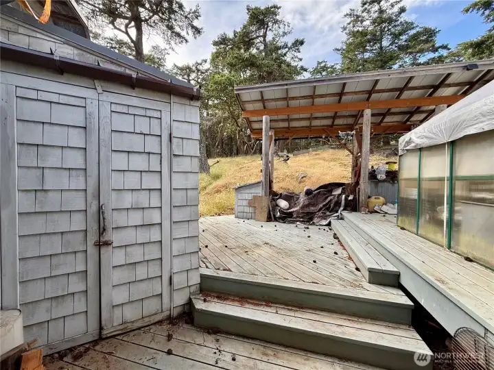 Back deck area with propane storage tanks and greenhouse. Back deck area with propane storage tanks and greenhouse.