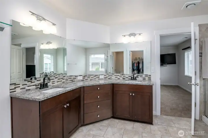 Spacious primary bathroom with granite countertops and plenty of natural light Spacious primary bathroom with granite countertops and plenty of natural light