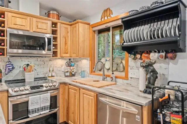 Remodeled kitchen w/Corian counters, backsplash, appliances, plate cabinet.