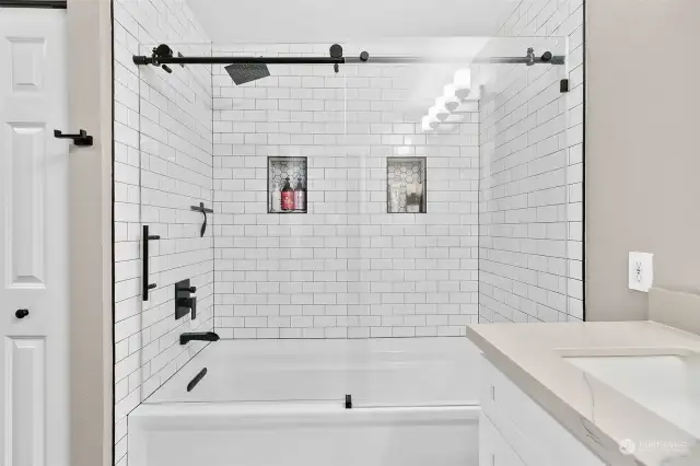 Indulge in luxury with a new, larger tub adorned with timeless subway tiles and elegant cutouts, creating a spa-like oasis for unwinding and rejuvenation.