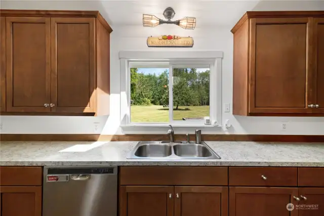 The kitchen window offers a view of the remodeled front yard, showcasing an extra-large apple tree that blooms with flowers in spring. Get ready to make apple pie!