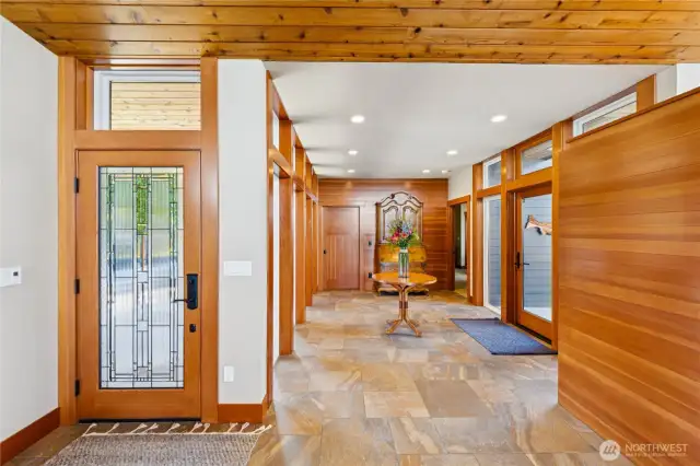 Warm natural wood and porcelain tile floors throughout the home; elegant entry welcomes guests and creates privacy and seperation between the owner's retreat and main level guest suite.