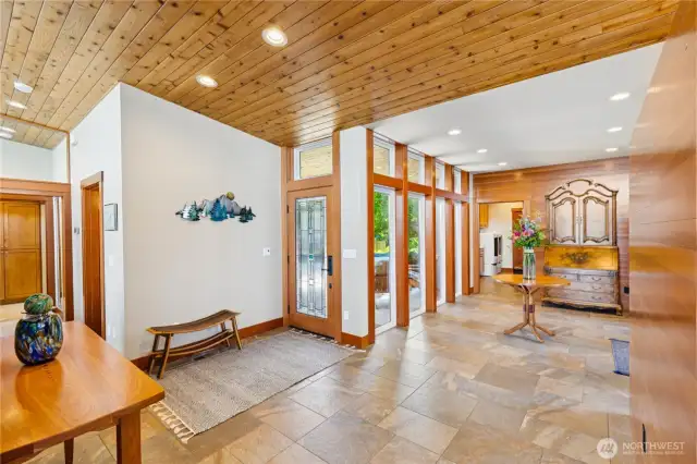 Looking back from the water side to the elegant entry, showcased by the warm wood trim and ceilings.