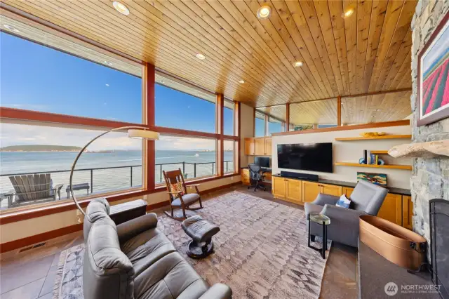 Beautiful fir ceilings enclose the warm living space while a wall of windows absorbs the water views.