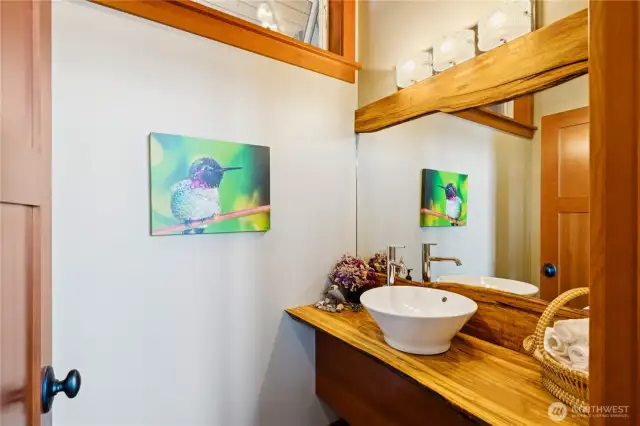 Custom details in the powder with a stunning wood mirrored surround and floating cabinet.