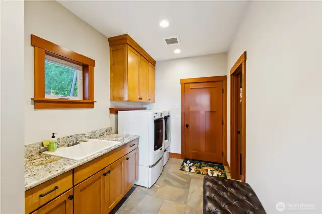 Oversized laundry room with ample counter space, cabinets and an additional walk-in pantry room.