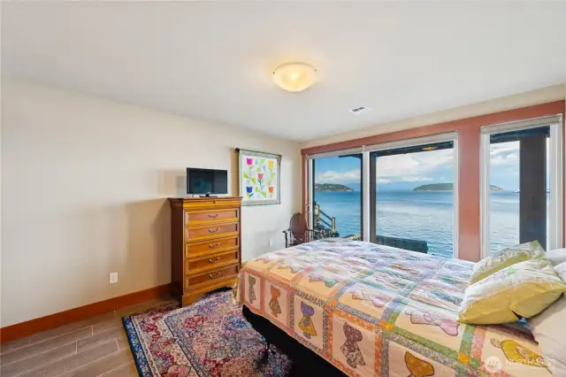 One of two lower level bedrooms with access to the covered deck and stunning views.