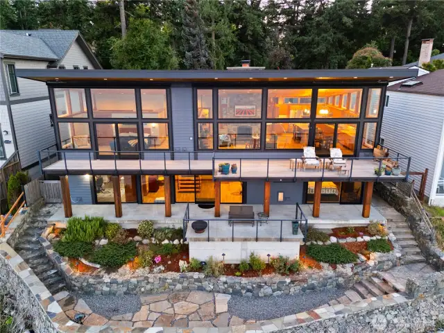 View of the home from the waterside showing the incredible amount of glass designed to absorb the warm sun and stunning views.