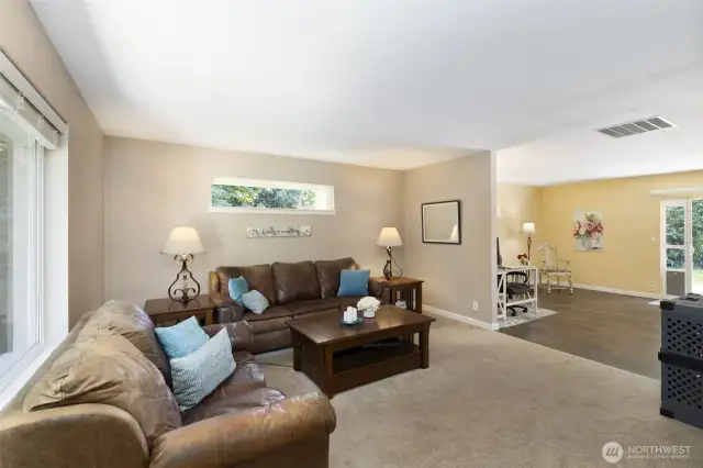 Living room in main home looking into additional living space (currently used as an office) and sliding glass door.