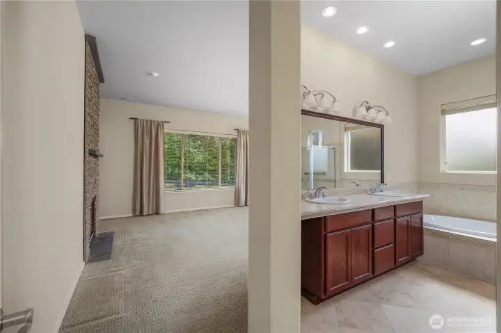 Primary bedroom and bathroom with gas fireplace, large closet and full tile shower.