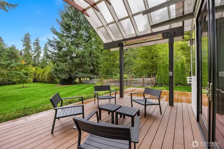 The home is set on a .72 acre lot. The back deck has views across the lawn to a cove of evergreens.