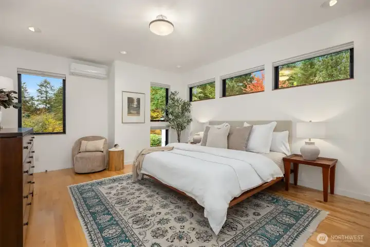 The private, upper primary suite with a large walk-in, organized closet. The room is large enough for a couple of sitting areas and a large bureau.