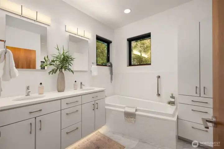 Spa-inspired bath with heated floor, Carrara marble vanity, heated floor, Duravit tub.