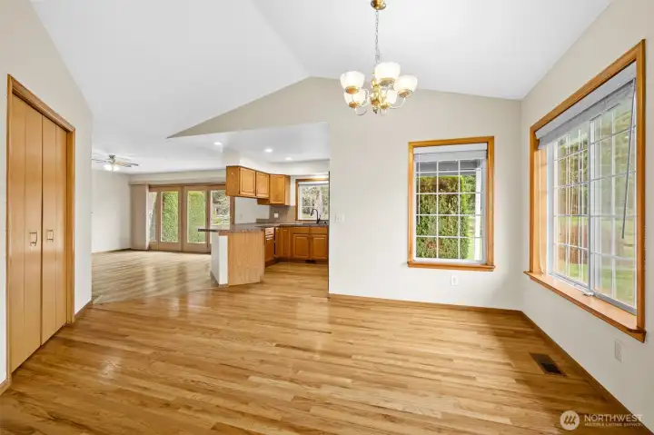 Dining area with vaulted ceiling open to the kitchen and adjacent family room.