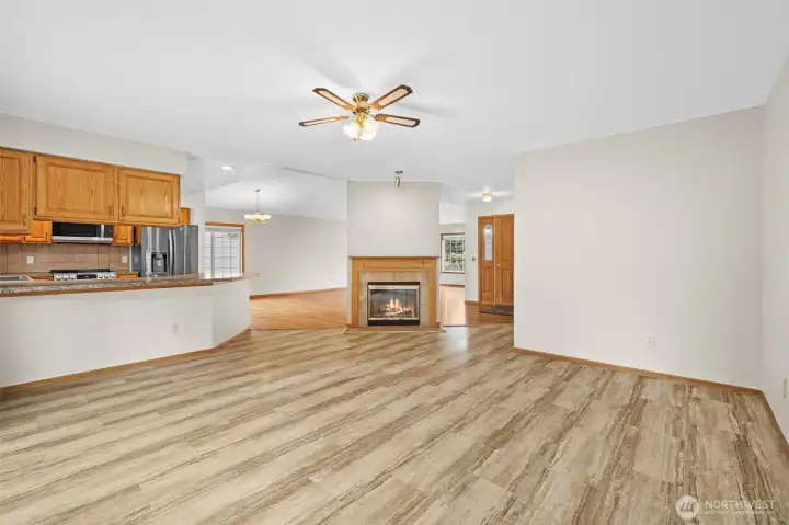 Open family room with fireplace and direct connection to the kitchen and entry areas.