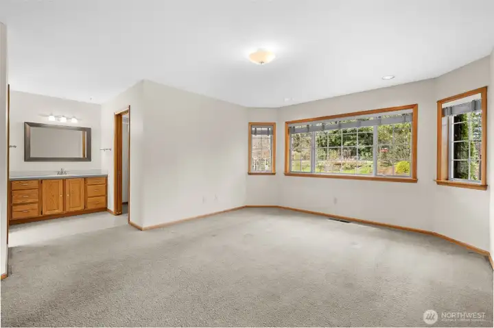 Primary bedroom with bay window, showing ensuite vanity.