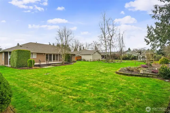 Spacious backyard with manicured landscaping and large deck overlook the fairway.