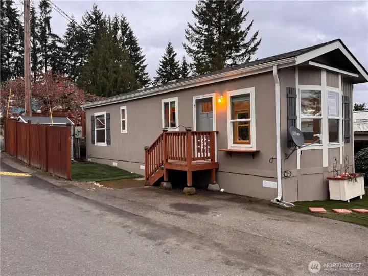 Well-maintained manufactured home with corner lot placement, and low-maintenance outdoor space.