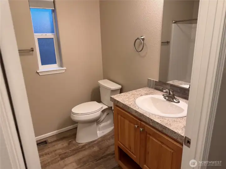 Well-maintained bath with vanity storage and window light.