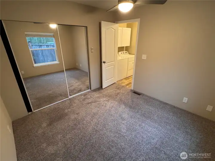 Cozy bedroom with fresh carpet and storage.