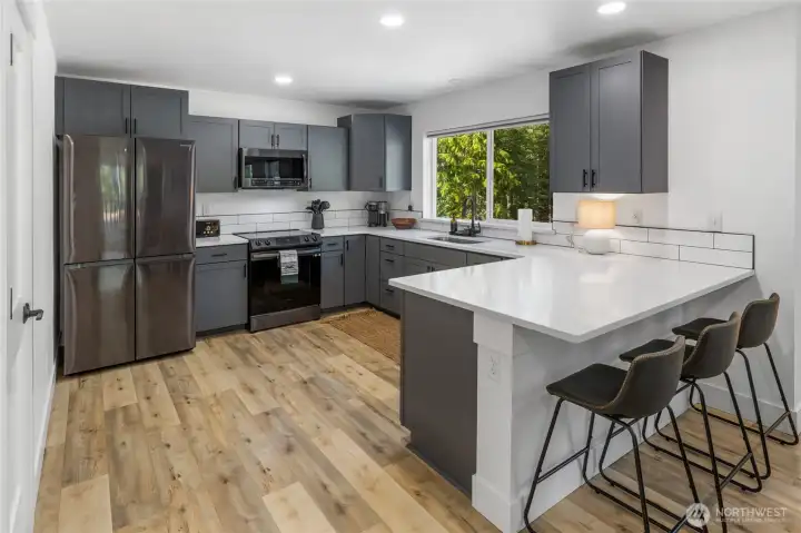 Great kitchen with an eating bar and large window allowing you to look out to see the beautiful yard.