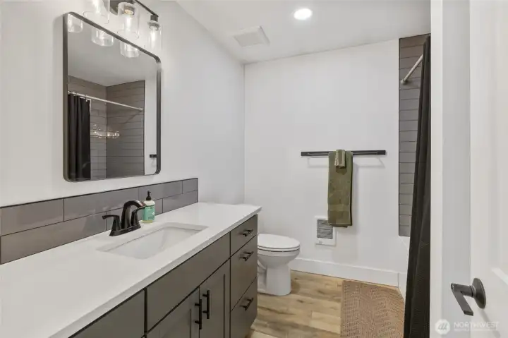The main floor bathroom has upgraded counters, a custom mirror, and tile work. Very classy!