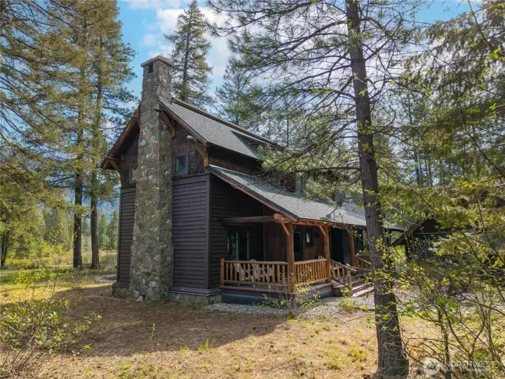 Stone fireplace chimney and wrap-around decks offer both aesthetic appeal and functional outdoor living spaces. The stone chimney adds a rustic, natural touch, while the wrap-around decks provide ample area for relaxation, entertaining, and enjoying the surroundings.