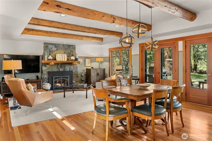 Open floor plan on the main level with exposed beams in the ceiling. Doors lead to decks on the north and south sides of the home.