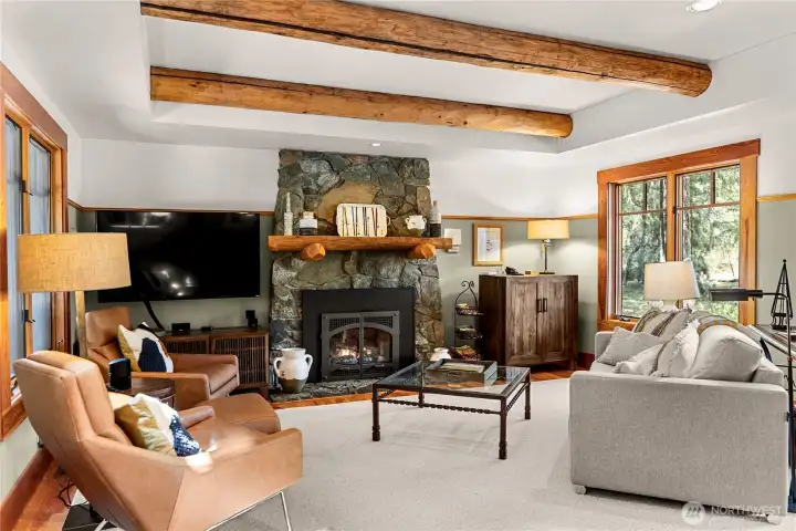 Bright interior spaces with a classic build and furnishings. The design seamlessly blends mid-century modern and casual rustic elements, beautifully complementing the stone and metal fireplace.