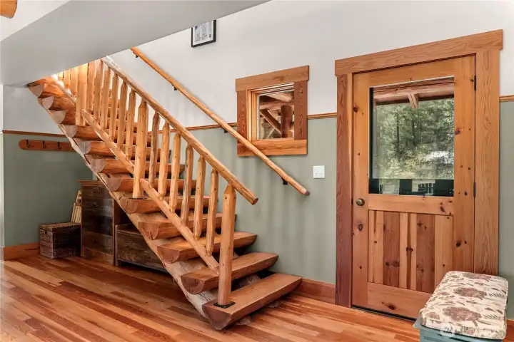 Open timber staircase leads to the upper floor, providing a unique and functional connection between levels.