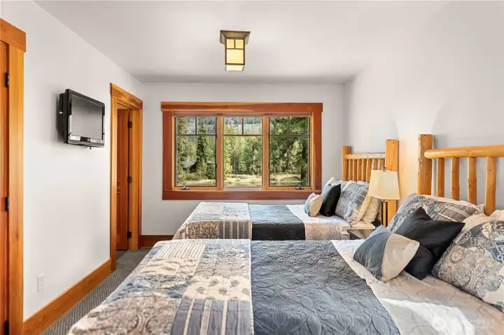 The second upper bedroom features two beds and a 3/4 ensuite bathroom.