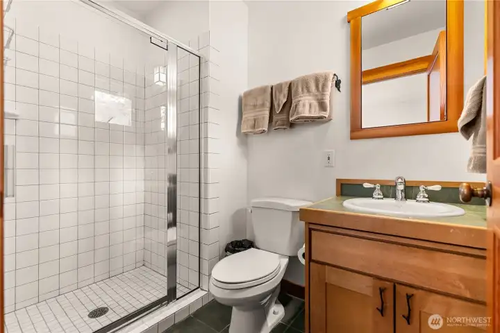 S Second bedroom's bathroom with tiled shower.