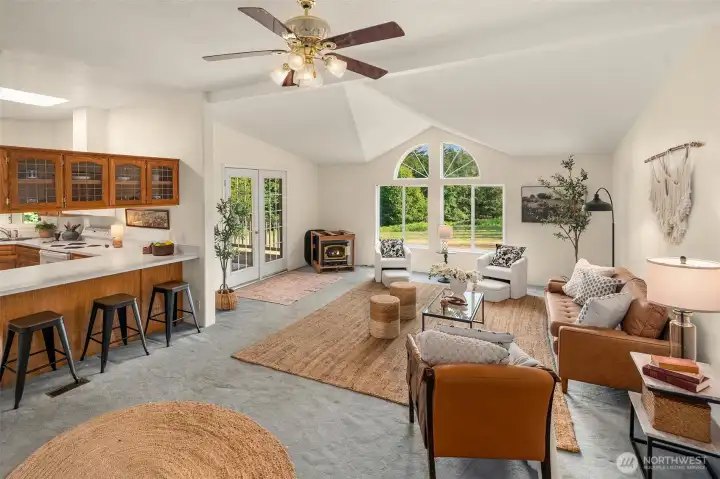 Nice view of eating bar in kitchen, family room and French doors out to the covered deck on the south side of the home. Previous owner planned to install a Lopi wood stove and all the parts are on-site.