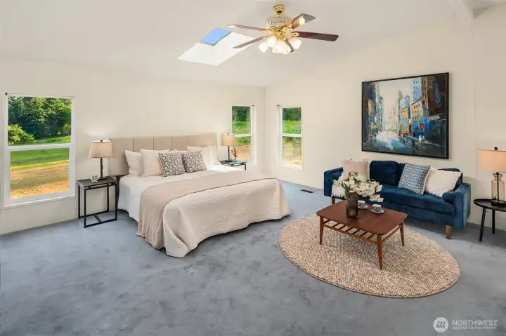 Primary bedroom on west side with skylight and many windows. Generous size allows for lounging or work-from-home space.