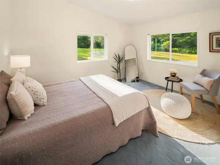 Secondary bedroom with windows on two sides and vaulted ceilings.