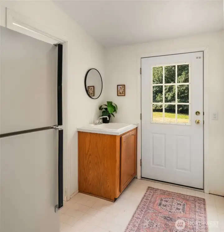 Laundry/mud entry with laundry sink and extra fridge.