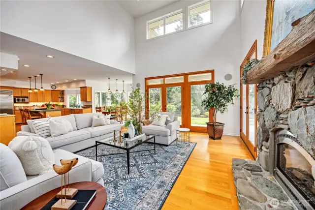The wonderful open floor plan is dramatic and flows seamlessly from one room to the next. The great room features beautiful hardwood floors, soaring ceilings and a propane fireplace with natural stone surround. Gorgeous vertical grain wood French doors open to the large decks/patio and level yard, providing a wonderful place to relax or entertain.