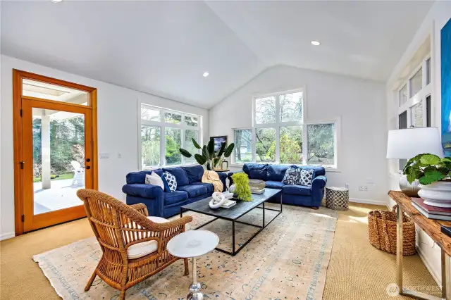The sun room is another fabulous place to relax! Drenched in daylight with soaring ceiling heights, walls of windows and a doorway to the covered deck, fire pit and patio.
