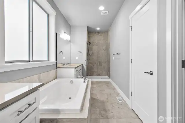 Spacious spa inspired primary bathroom, double sinks, soaking tub and frameless shower!