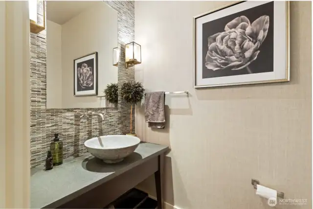 Stylish half bath on the main level includes custom fabric wallpaper and high-end fixtures.