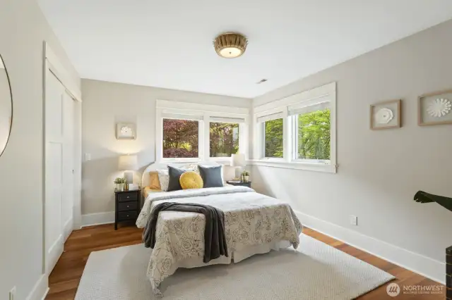 Third upstairs bedroom with serene green views of the backyard.