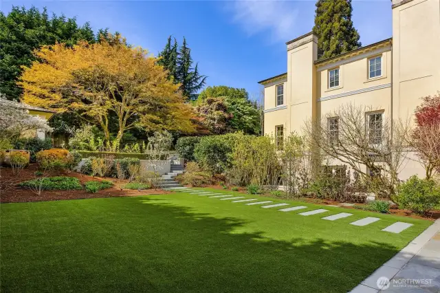 The "lower yard" is to the side of the home and is enormous!  Great for croquet, a play structure, pickleball court and/or a pool if you like! Not visible from the street and gated so that if young kids are playing there they are not able to exit!
