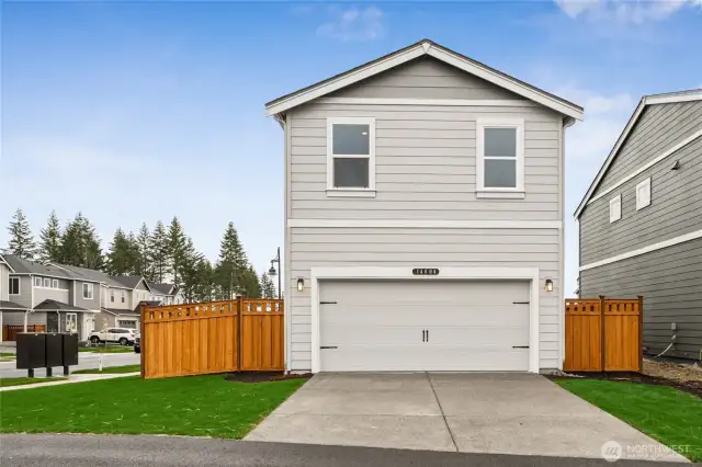 Rear-facing two-car garage with alley access, fenced yard, and charming exterior design.  Pictures are for representational purposes only, colors and features may vary.