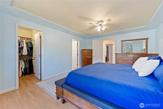 Walk-in closet has additional storage space behind the door and en-suite bath is located just through the open doorway to the right of the closet.