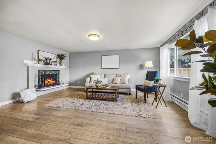 Bright, open living room featuring a wood burning fireplace.