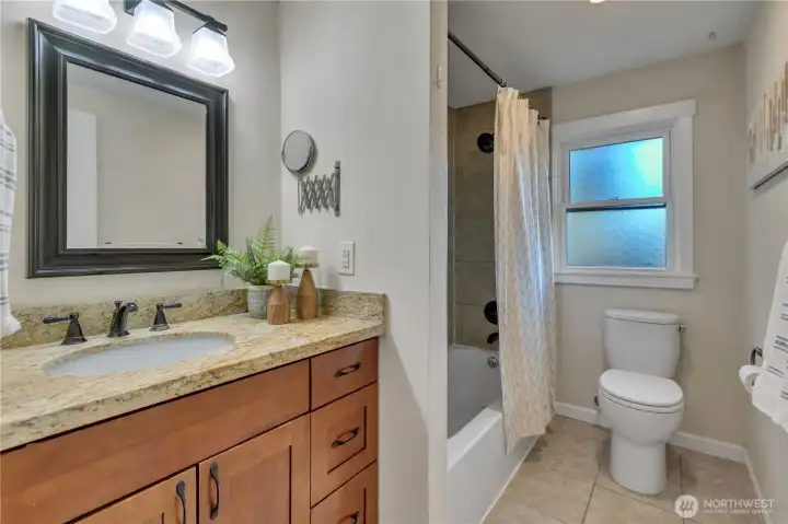 Upstairs full bathroom has granite counters and a tiled shower.