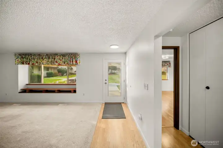 Front door into living room. Primary bedroom to the right.