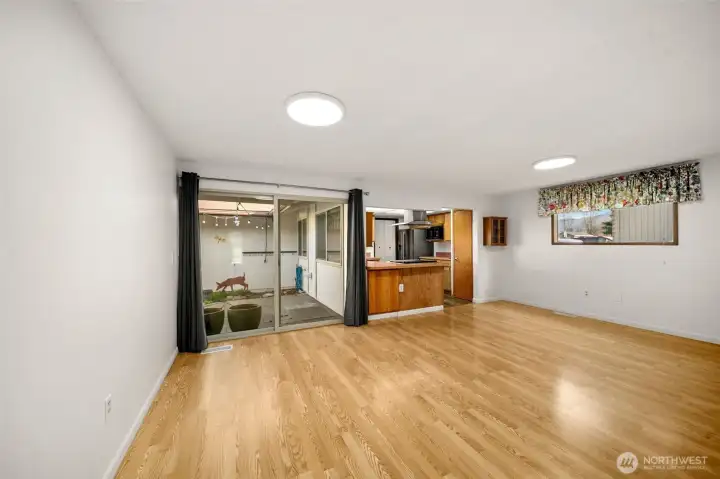 Dining room area, looking out towards the patio, with the kitchen to the right.