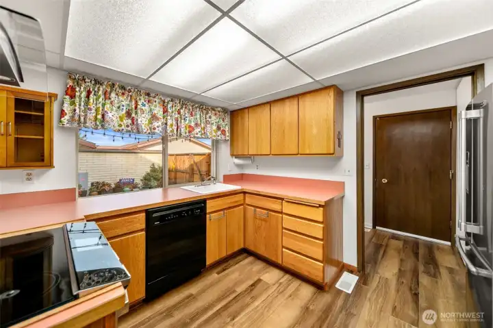 Kitchen with window over-looking the private patio area. Door to garage on the right hand side.