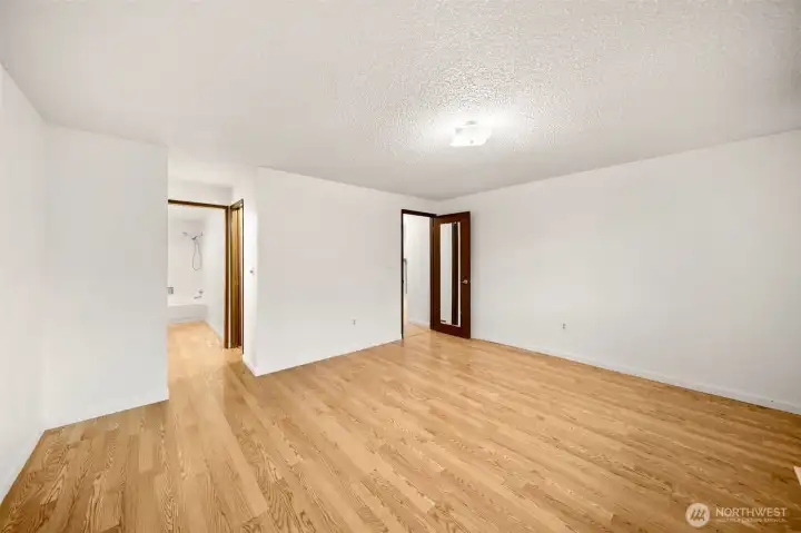 Primary bedroom looking towards the primary bathroom and door to hallway.